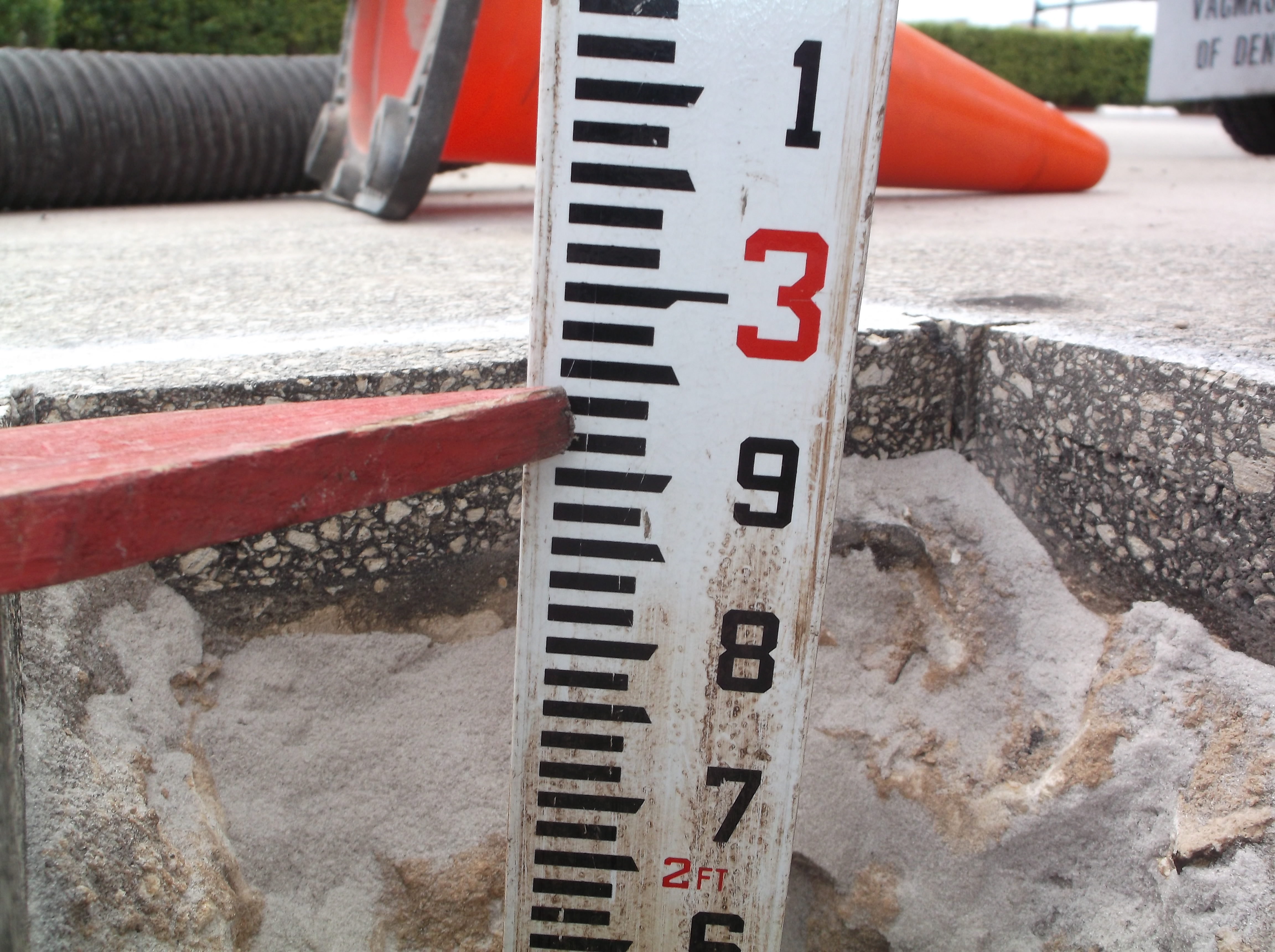 Depth rod measuring inside a utility pothole — vacuum excavation test hole depth measurement South Florida